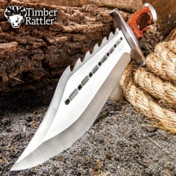 Large spiked bowie knife with wooden handle on dirt