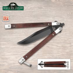 Butterfly knife with wooden handles and black blade on wood background