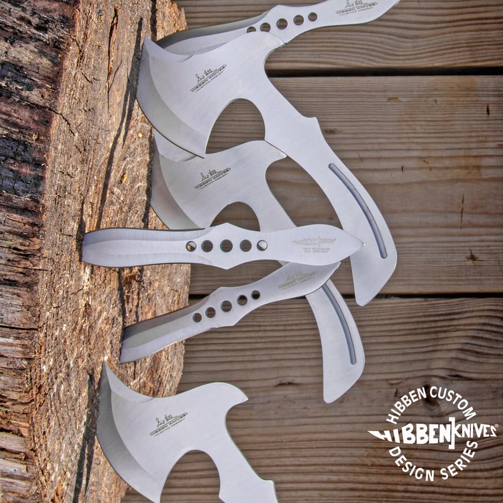 3 stainless steel throwing knives and 3 stainless steel throwing axes imbedded in a wooden stump. Bottom right corner "Hibben Custom Design Series" encircling "Hibben Knives" logo. image number 0