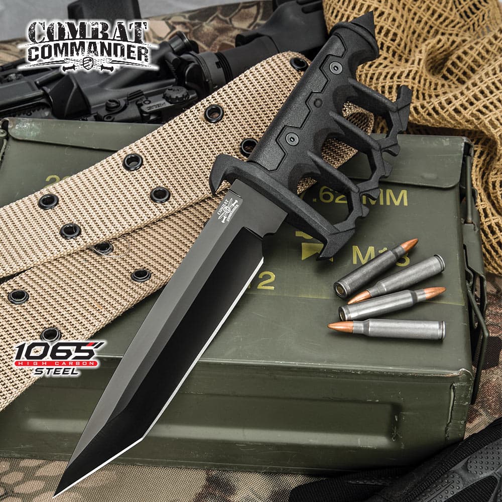 Combat Commander Trench Knife has a 1065 carbon steel blade and cast metal handle with rubberized grip inserts, shown on ammunition background. image number 0