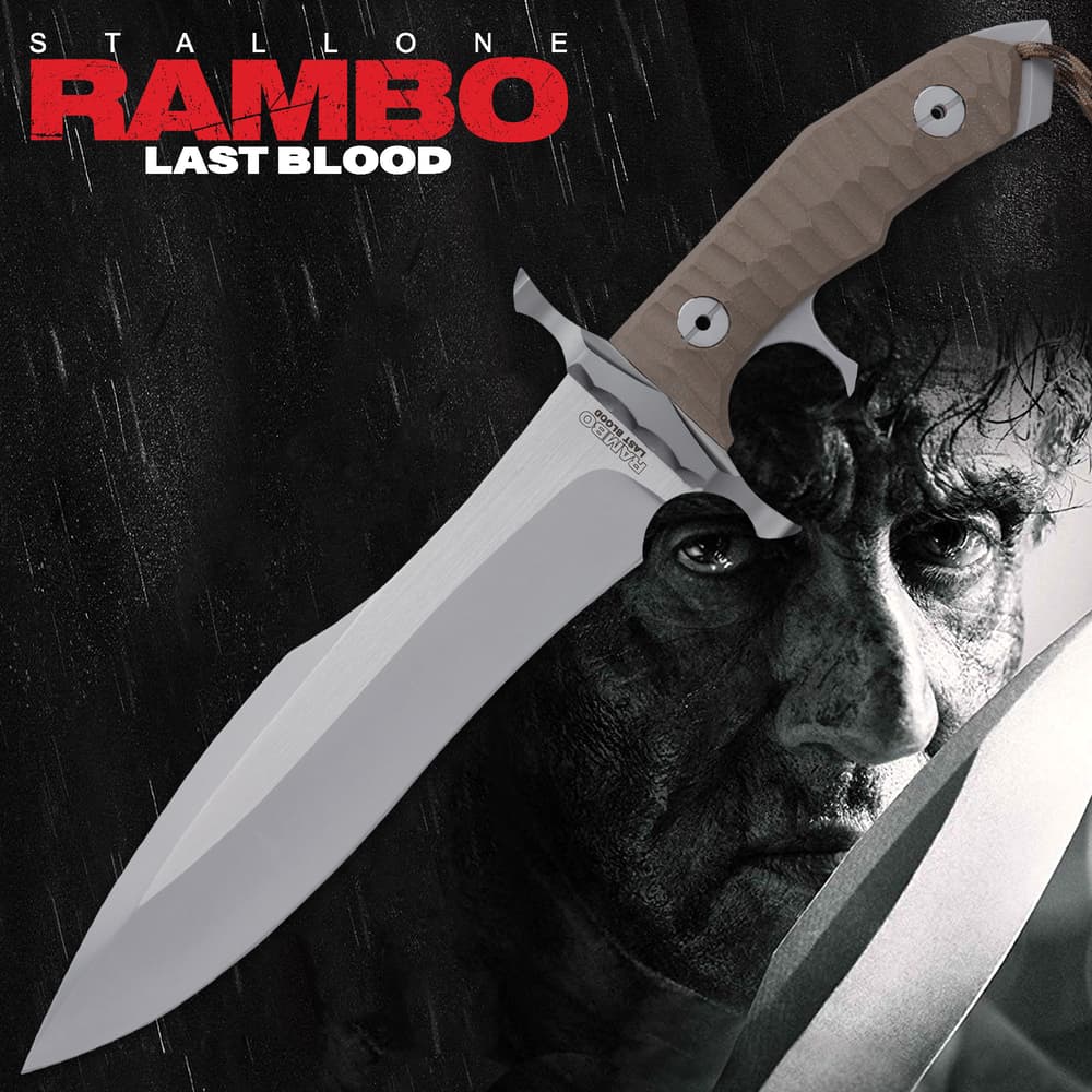 9" stainless steel blade with taupe handle and hand guard with Stallone Rambo Last Blood background. image number 0