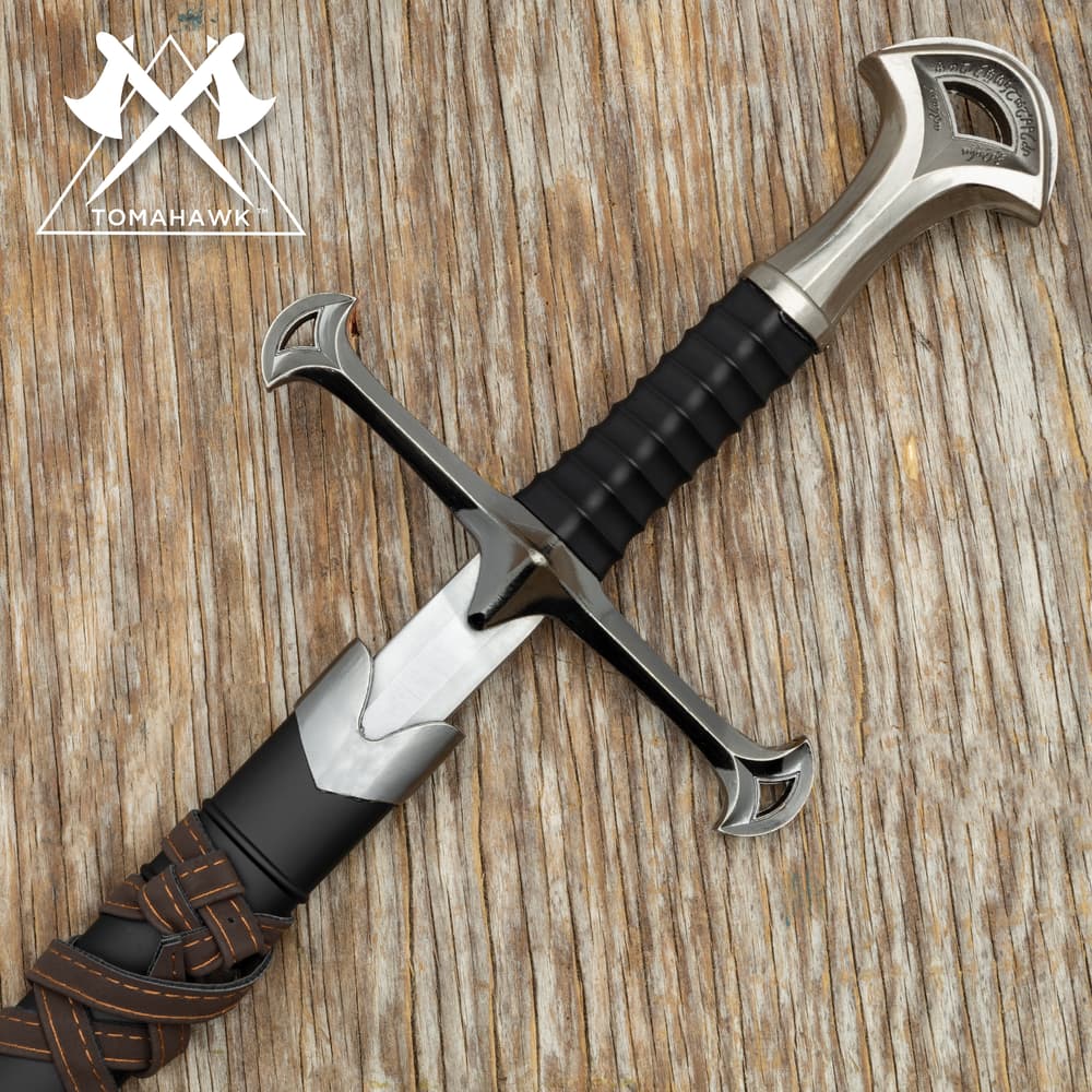 Close view of Medieval warrior short sword with black sheath wrapped in brown leather belt and a pewter metal alloy cross shaped handle and guard image number 0