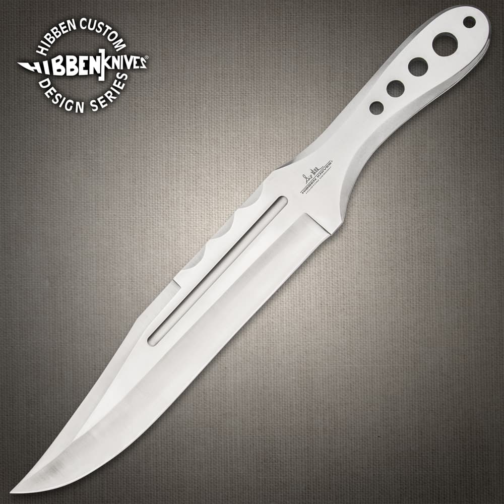 Polished stainless steel throwing knife with several thru-holes on a wood background. image number 0