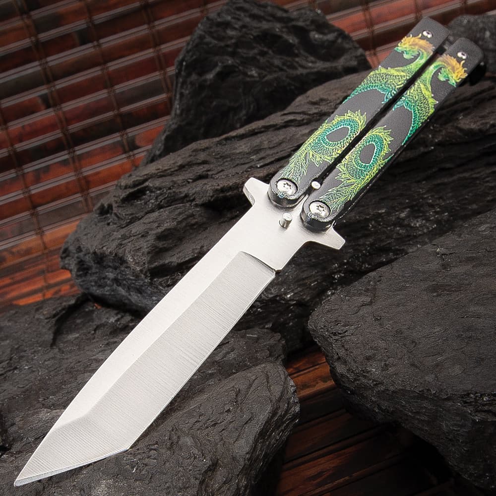 The Twin Dragons Green and Yellow Butterfly Knife has a 4” stainless steel blade with satin finish and black steel handles with dragons. image number 0