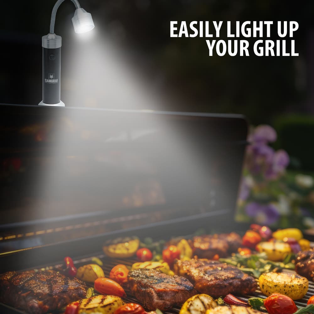 Full image of Grilling Lights magnetically attached to a grill with the light on. image number 1