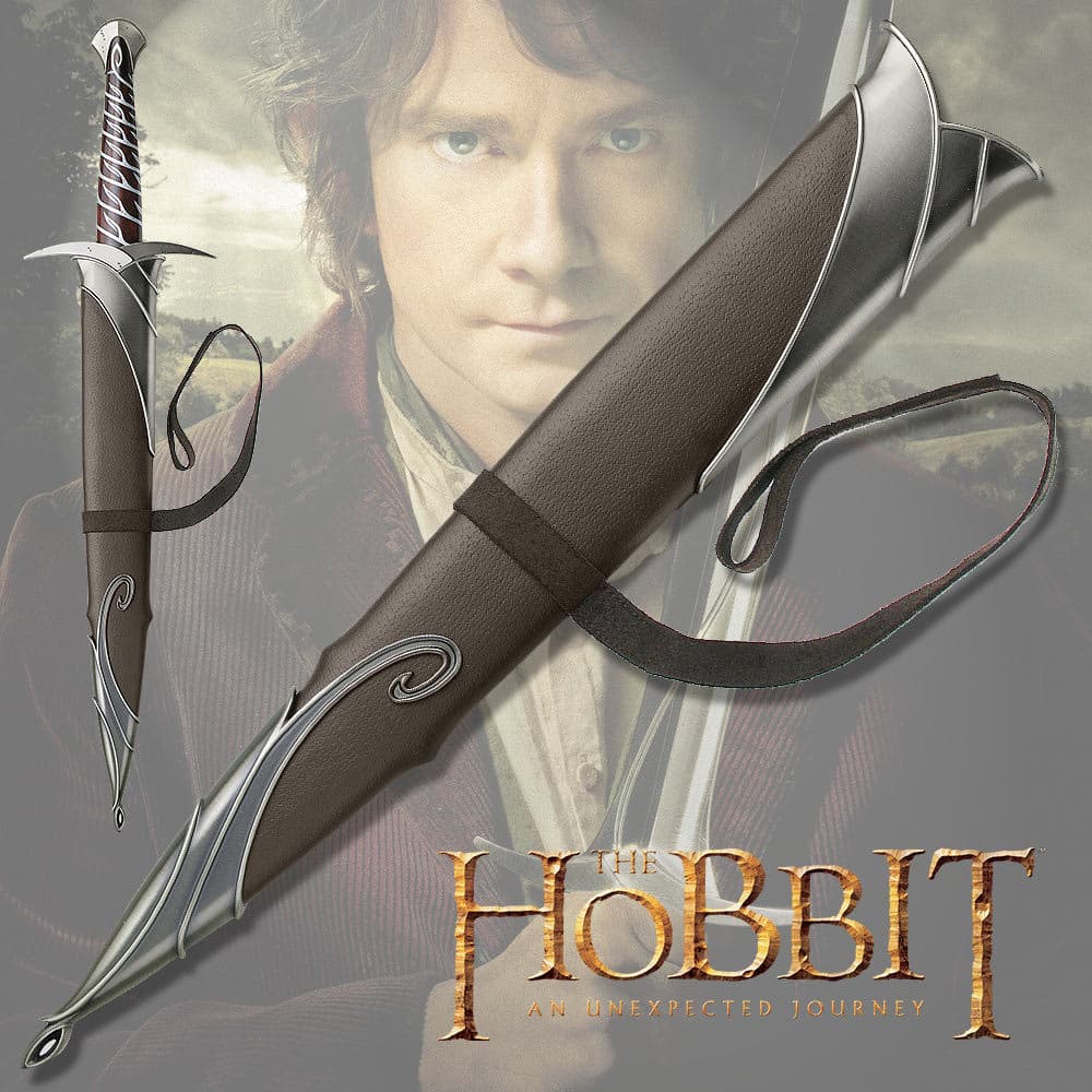 The Sting sword scabbard has metal fittings and leather belt strap, shown atop The Hobbit character Bilbo Baggins holding the Sting sword. image number 1