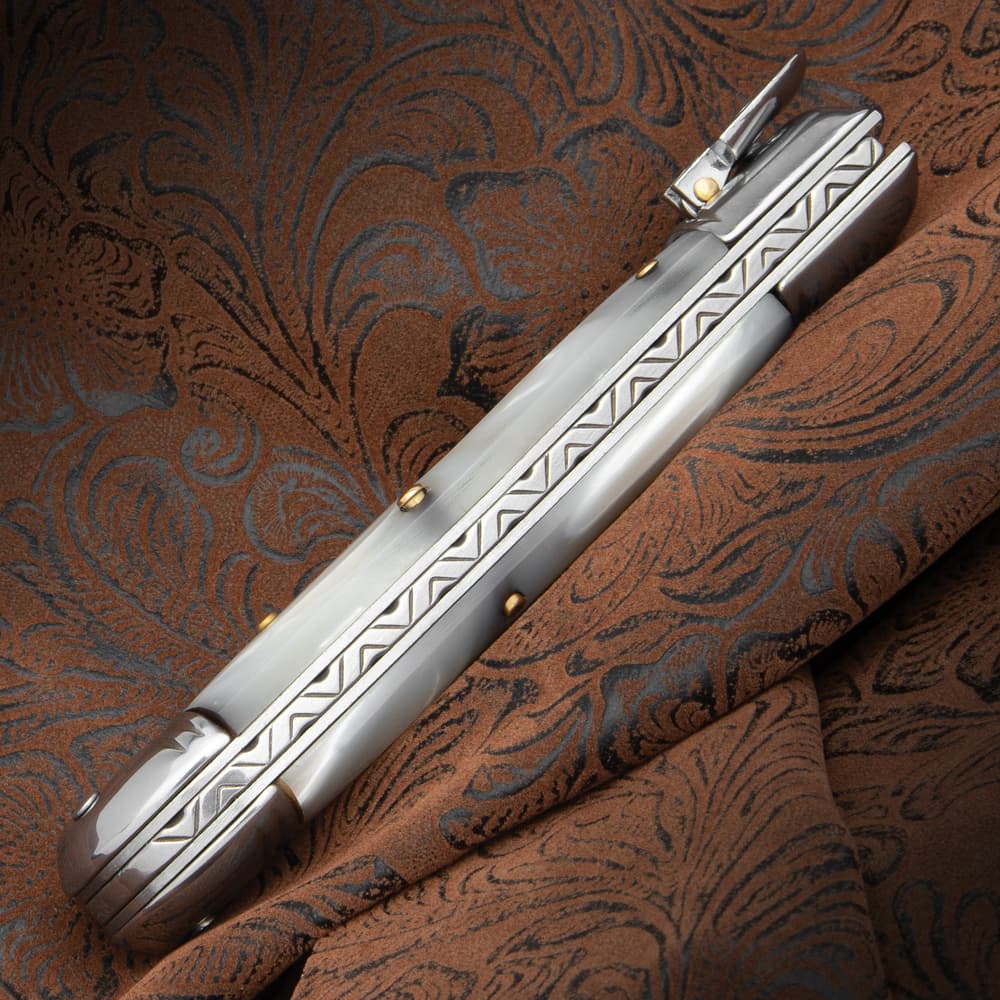 A close-up of the automatic knife's handle with its fileworked spine image number 1