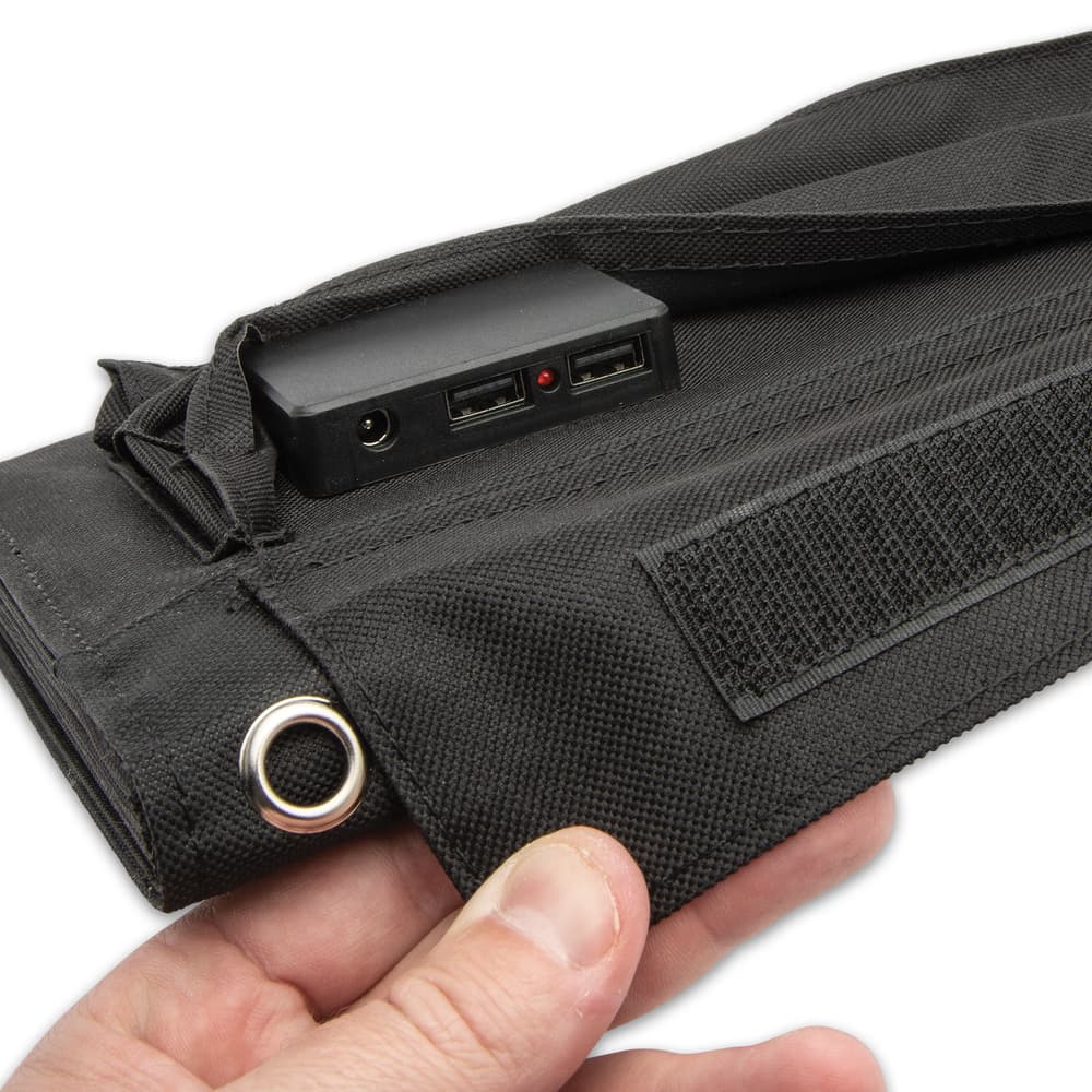 Inside of a pocket with a Velcro flap closure, there are two USB ports and a DC jack to plug in a variety of electronics image number 1