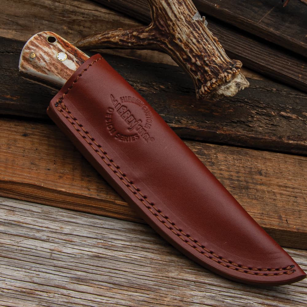 The fixed blade in its leather sheath image number 1