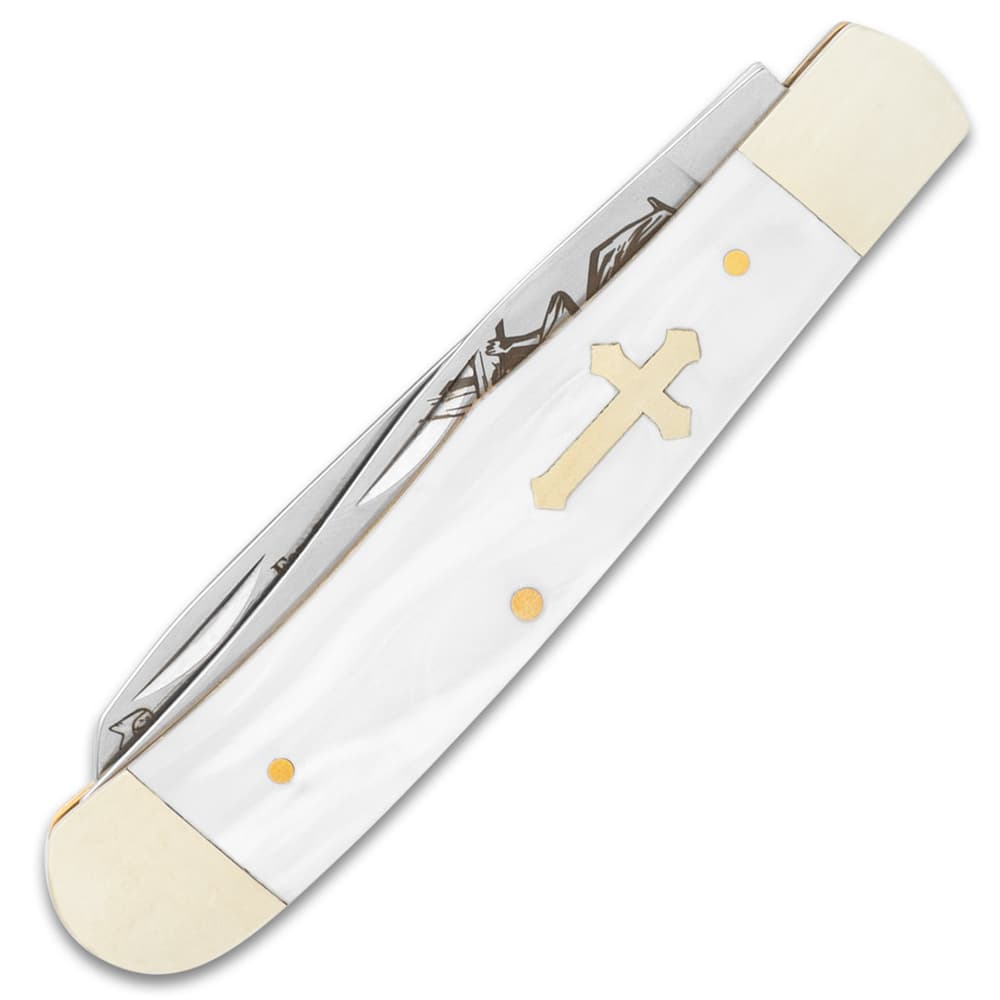 The faux pearl handle scales have an inlaid brass cross image number 1