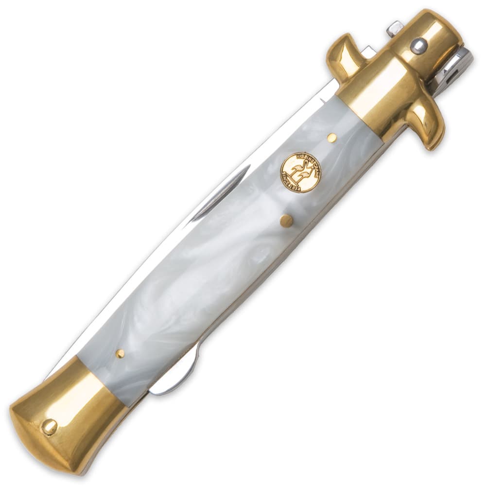The knife’s mother of pearl handle is accented by brass-plated pins, bolsters, and shield. image number 1