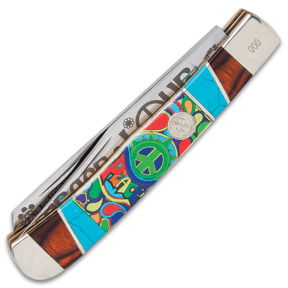 The handle is white bone with colorful, 3D-printed peace sign artwork, accented with wooden and teal blue panels image number 1