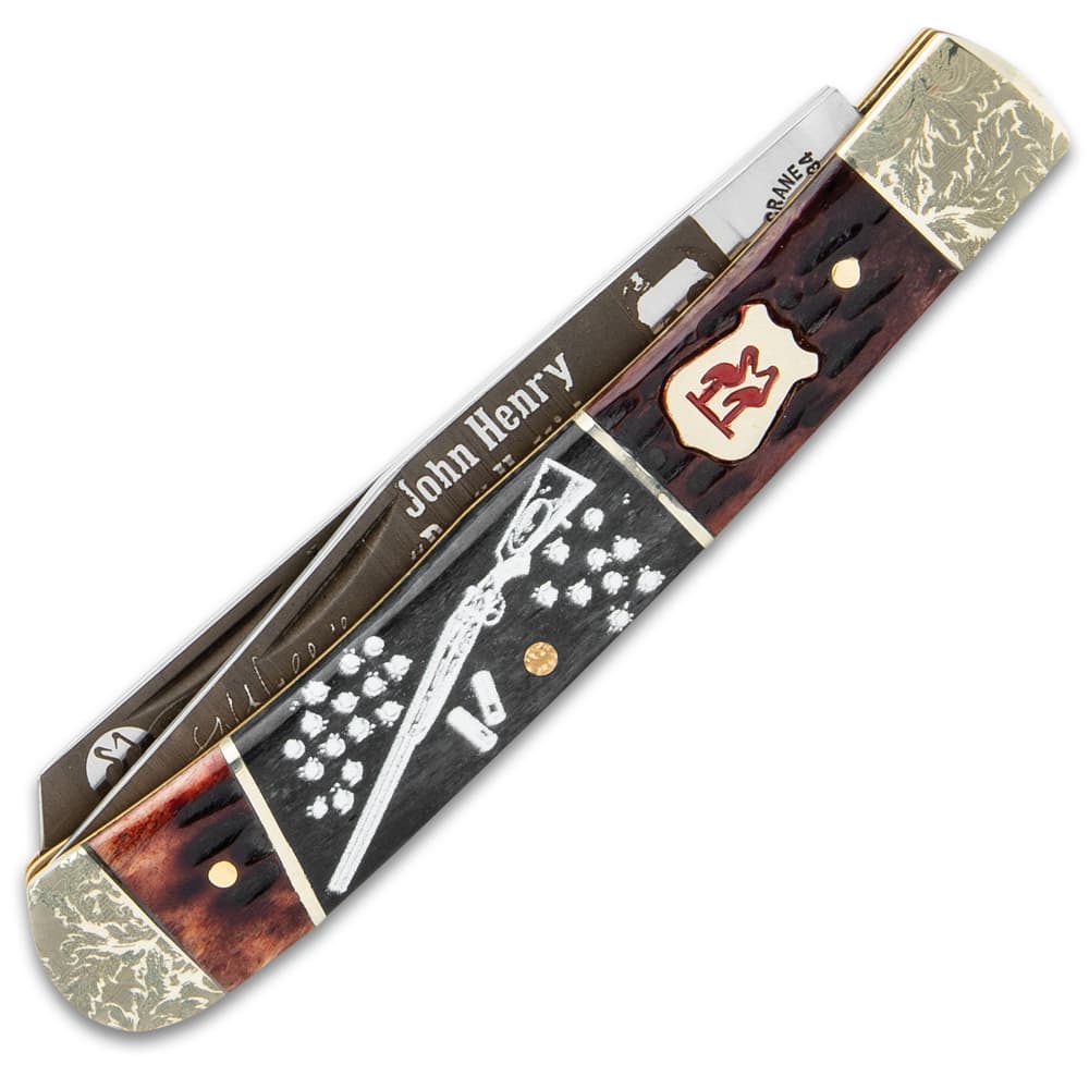 The handle scales are black and brown jigged bone with artwork. image number 1