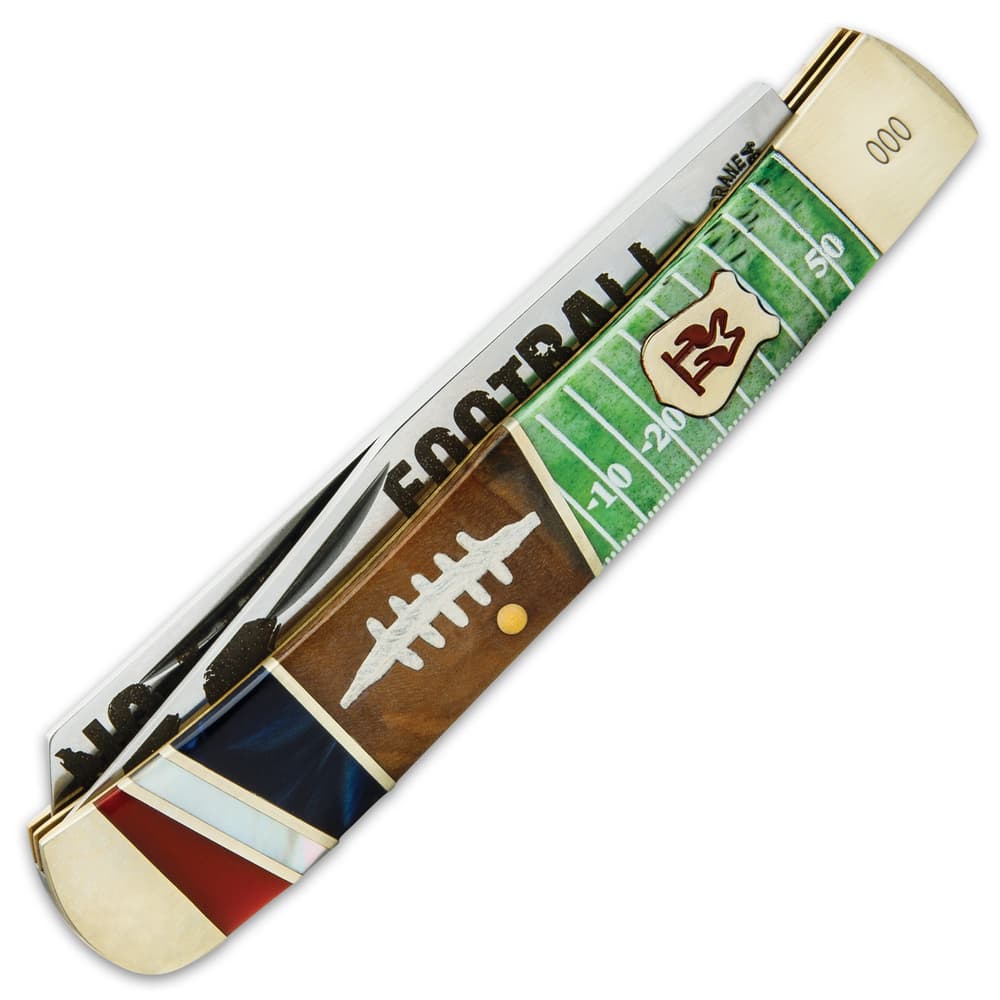 The colorful handle is crafted of wood, bone and acrylic panels with 3-D printed football-themed artwork and brass spacers image number 1