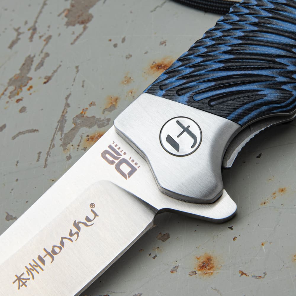 Closed Pocket knife with shining silver accents and a blue and black tie-dye style handle. image number 1