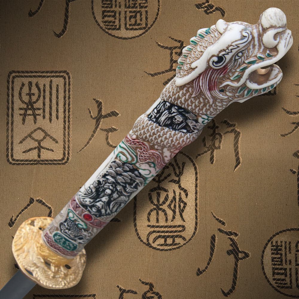 View from the top of the faux ivory handle with intricate designs and dragon head. image number 1