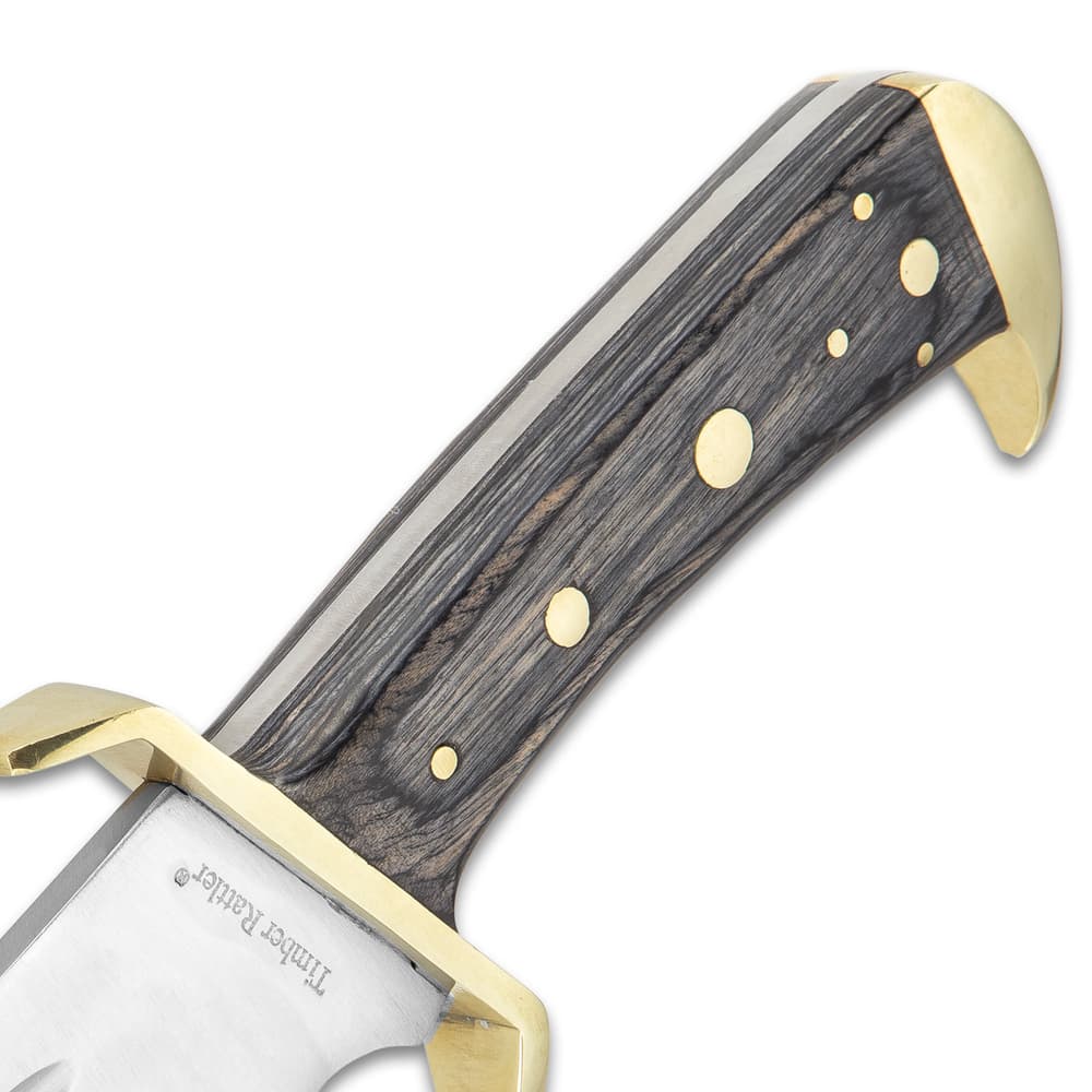 Detailed view of the classic gray hardwood handle with brass pins and brass-plated guard. image number 2