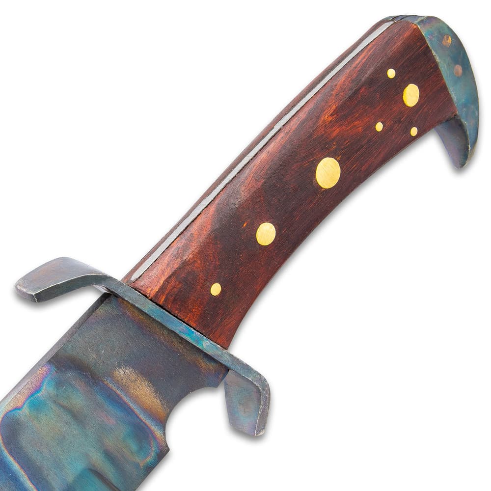 Detailed view of the knife’s brown hardwood handle with brass pin accents and aged steel, hawkbill pommel. image number 2