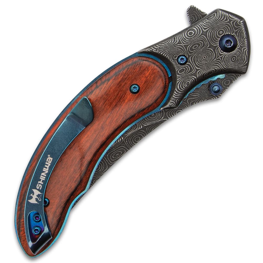Closed bloodwood pocket knife with "raindrop" pattern steel blade and metallic blue accents and pocket clip with the inscription "shinwa." image number 2