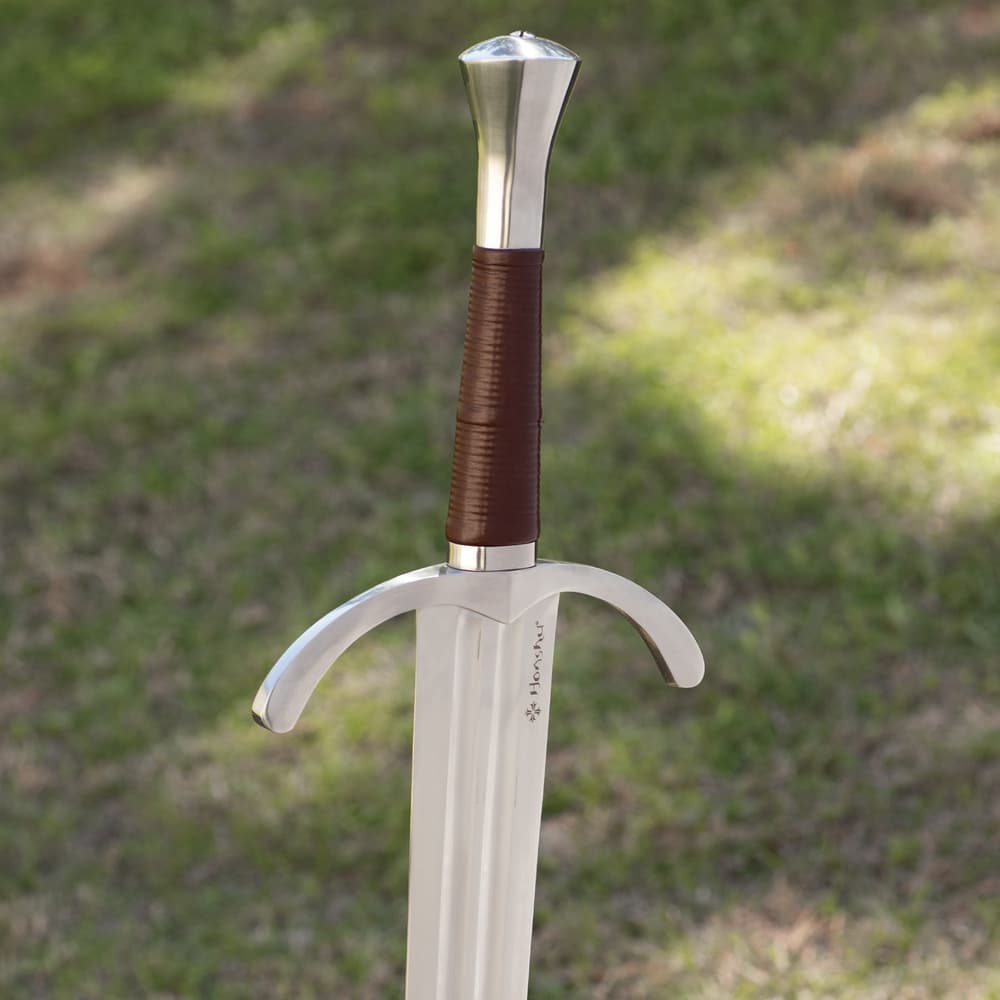 Stainless steel blade attached to polished handguard and wood handle wrapped in brown leather with hefty steel pommel image number 2