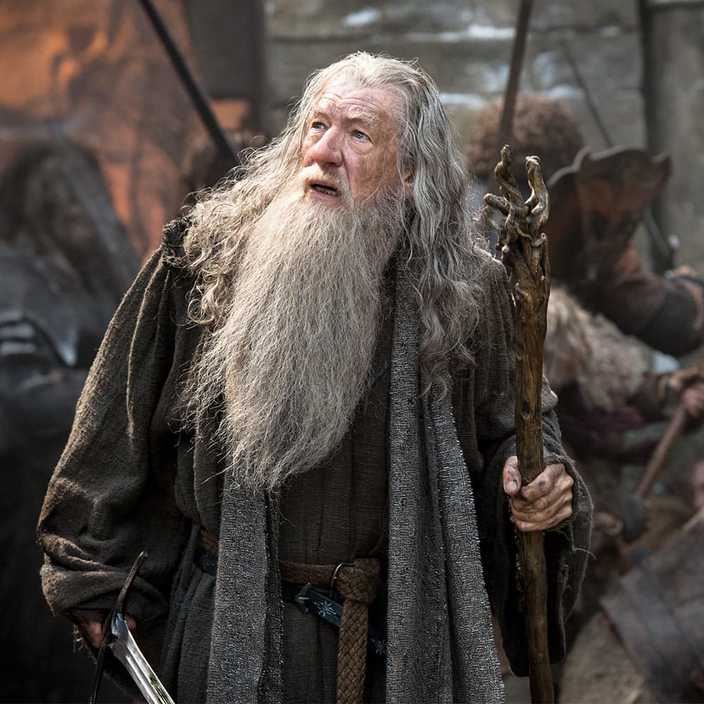 The Hobbit character Gandalf is shown holding the staff in a movie still. image number 2