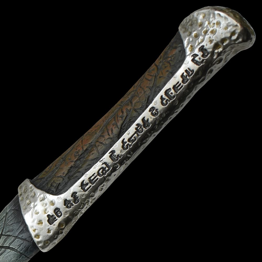 Upclose view of a dune replica knife with intricate glyphs and patterns along the handle with some artificial aging. image number 2
