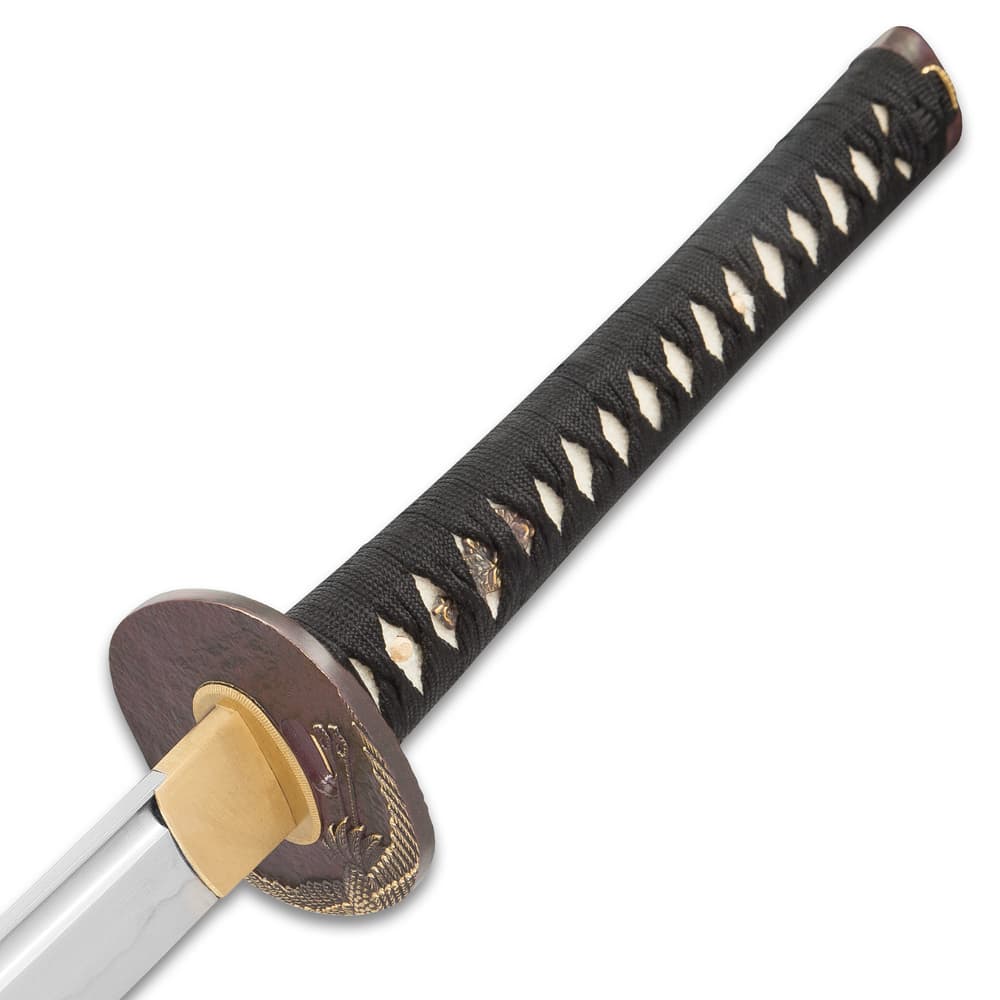 Zoomed view of the white ray skin handle with black braided cord wrapped and brass menuki. image number 2
