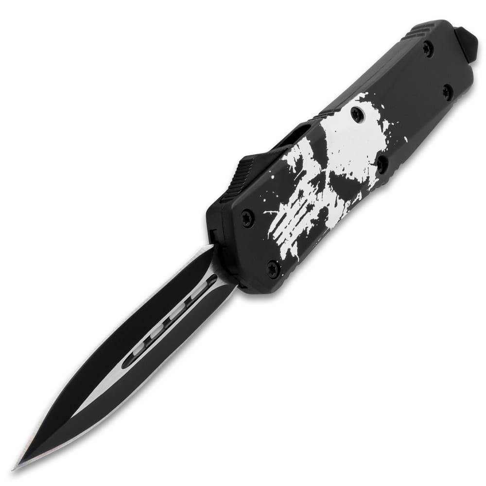 Open OTF pocket knife with dual-toned dagger style blade and a black handle with a large white distressed skull print, glass breaking pommel, and sliding trigger. image number 3