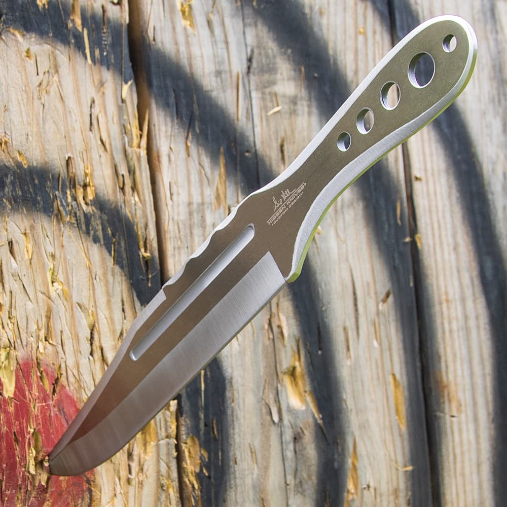 Mirror polished "Gil Hibben" throwing knife imbeded into the bulls-eye of a wooden target. image number 3