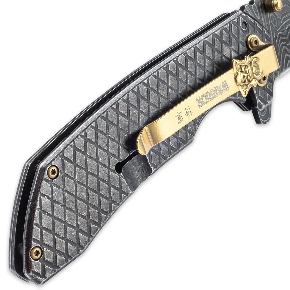 On the back of the knife is a gold pocket clip with Samurai skull medallion. image number 4