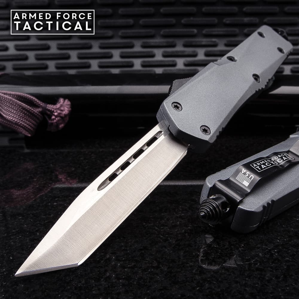 Tactical knife with a sharp blade on a textured surface image number 0