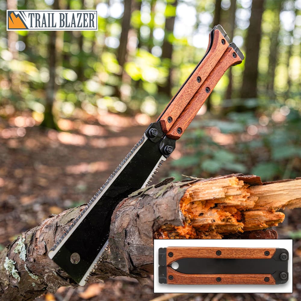 Folding saw with wooden handle on a log in forest image number 0
