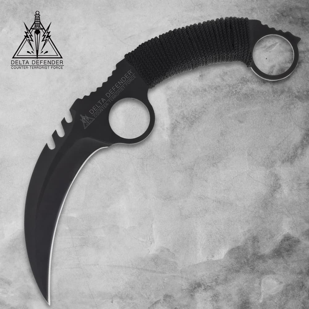 Black karambit knife with cord-wrapped handle on gray background image number 0