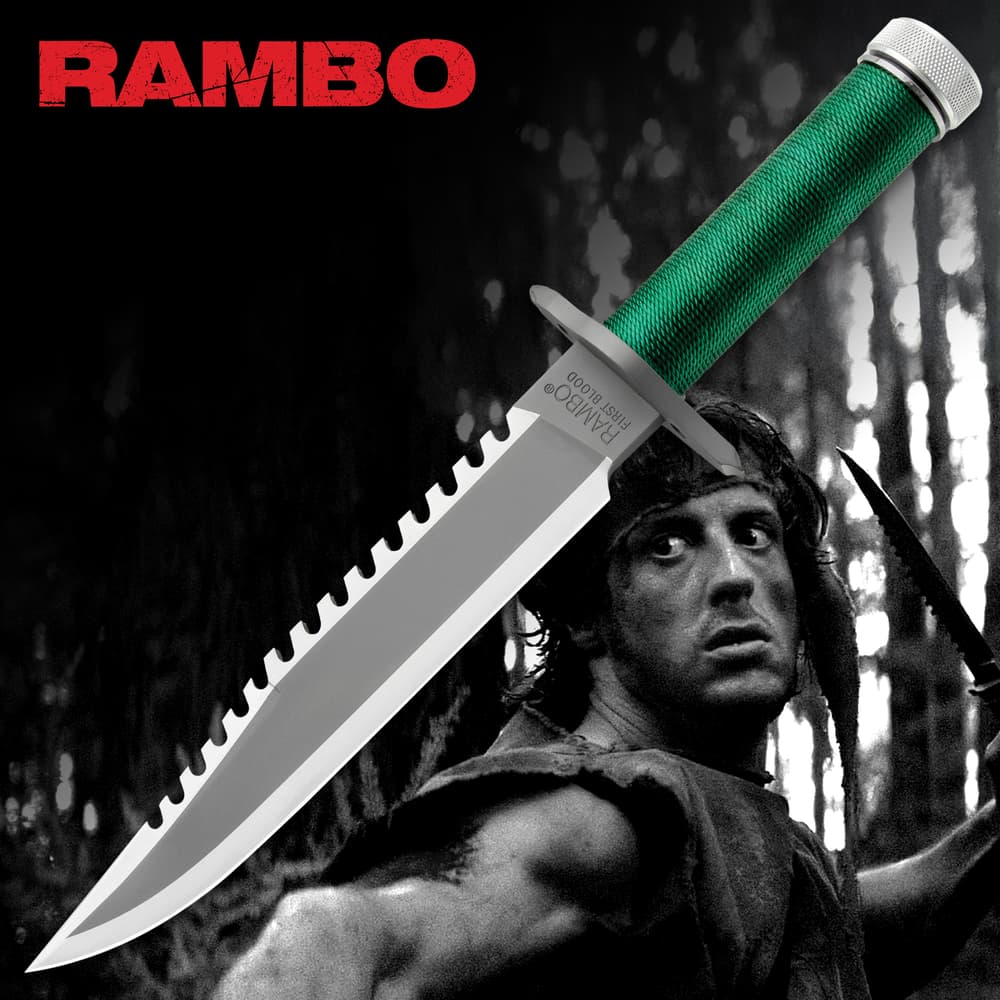 Rambo First Blood Licensed Rambo Knife with distinct saw-toothed spine alone the top blade. Handel wrapped in green material ending in metallic pommel image number 0