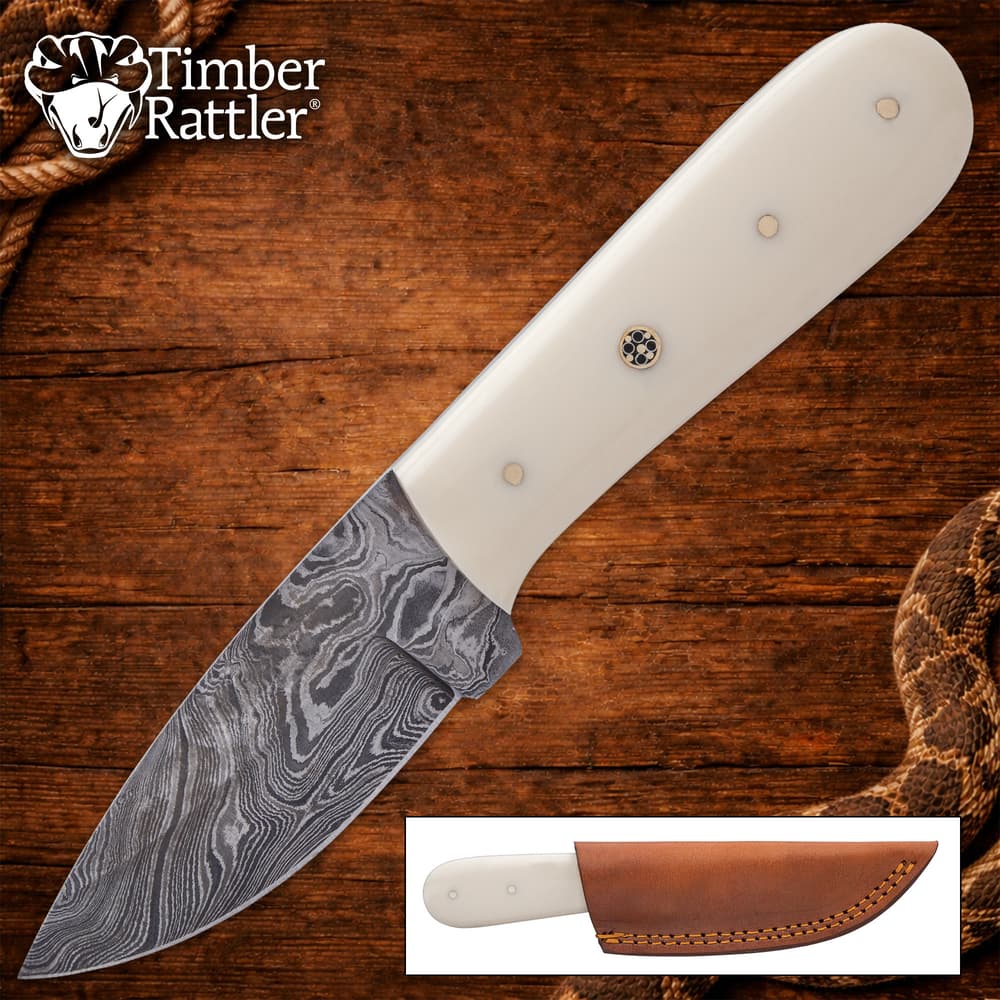 Knife with white handle and Damascus steel blade on wood background image number 0