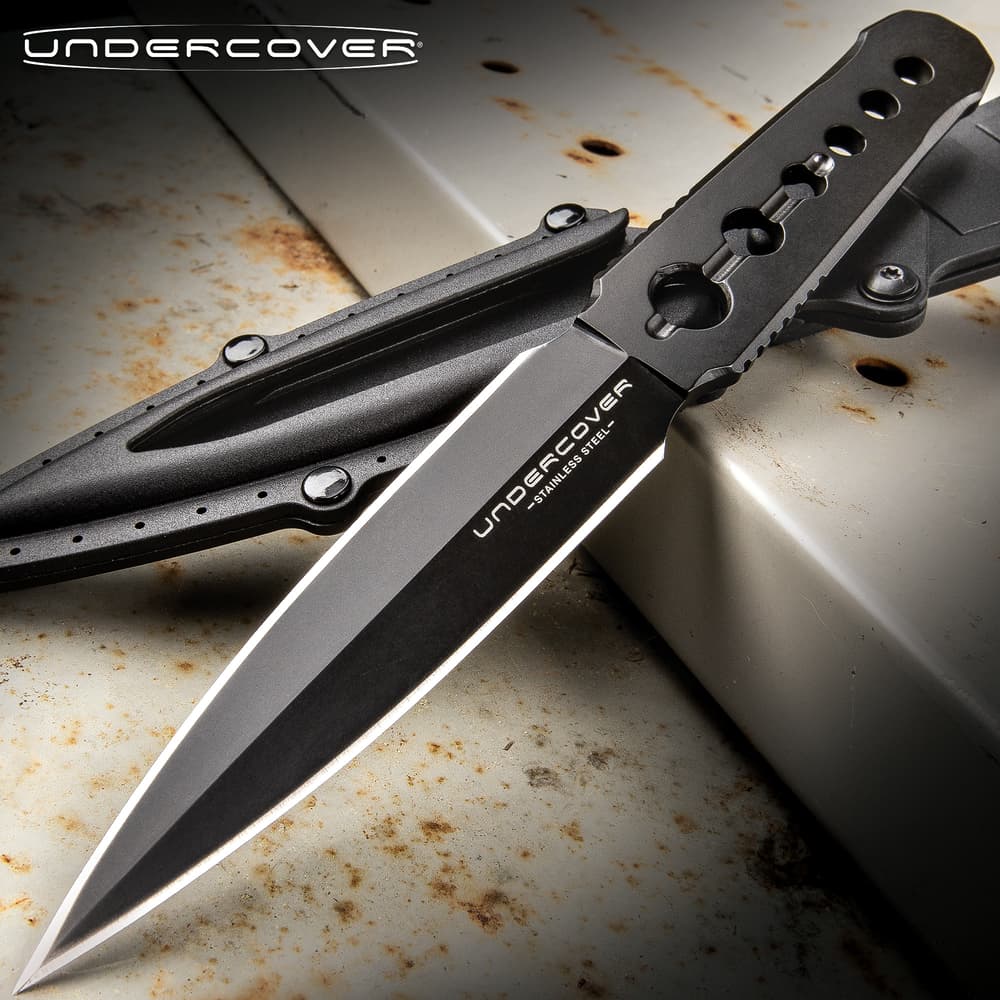 Black dagger with sheath on rusty metal surface image number 0