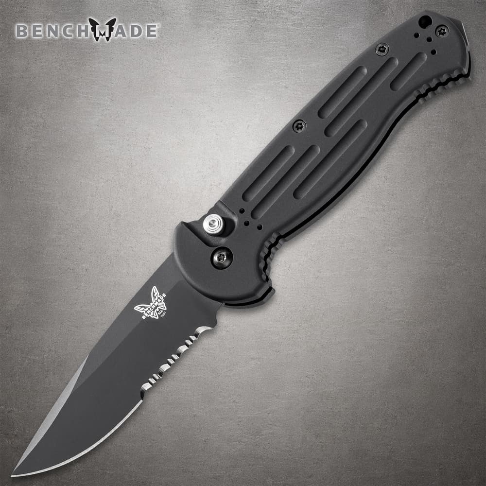 Black folding knife with serrated blade on gray background image number 0
