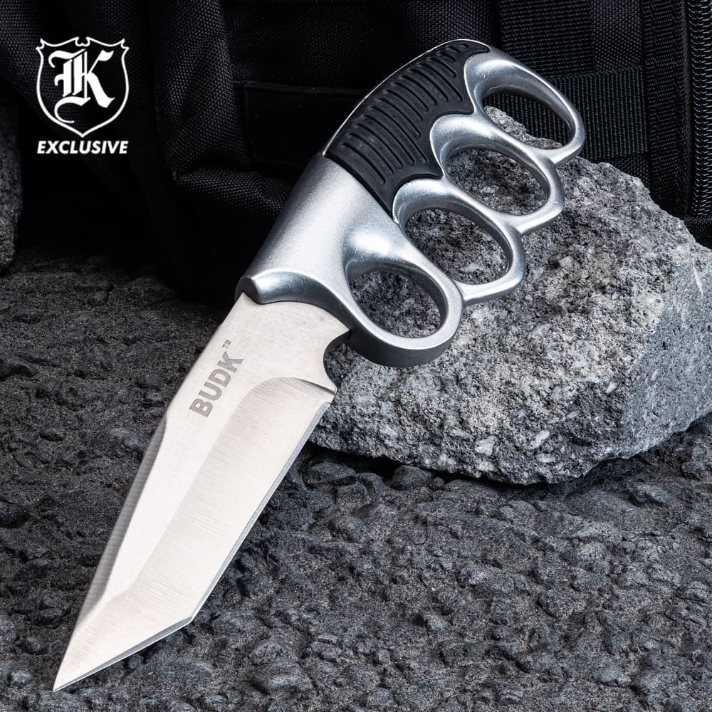 Knife with knuckle grip on rocky surface image number 0