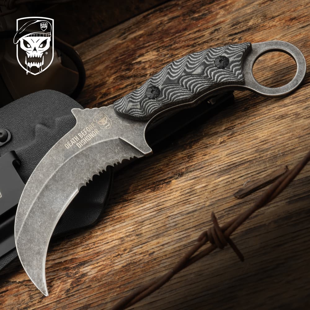 Curved knife with textured handle on wooden surface image number 0
