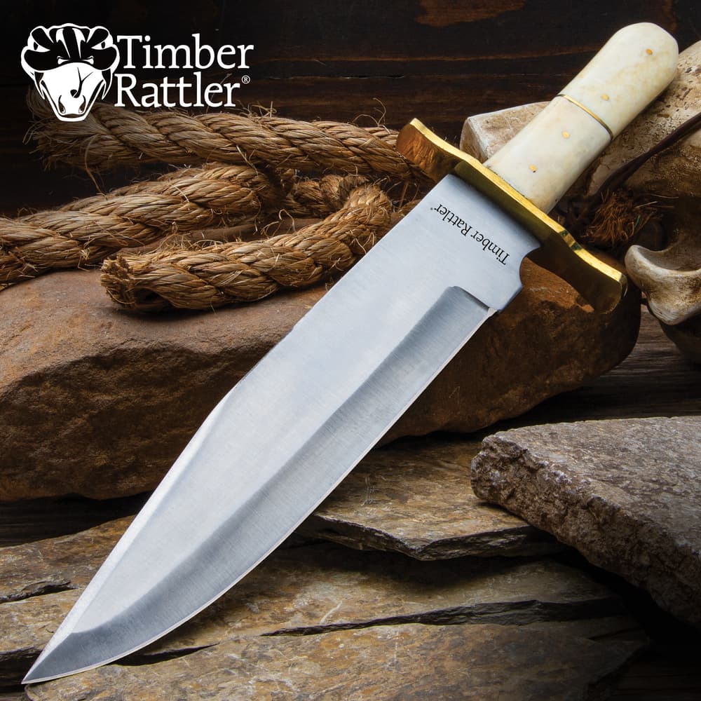 Large knife with ivory handle on rocks and rope image number 0