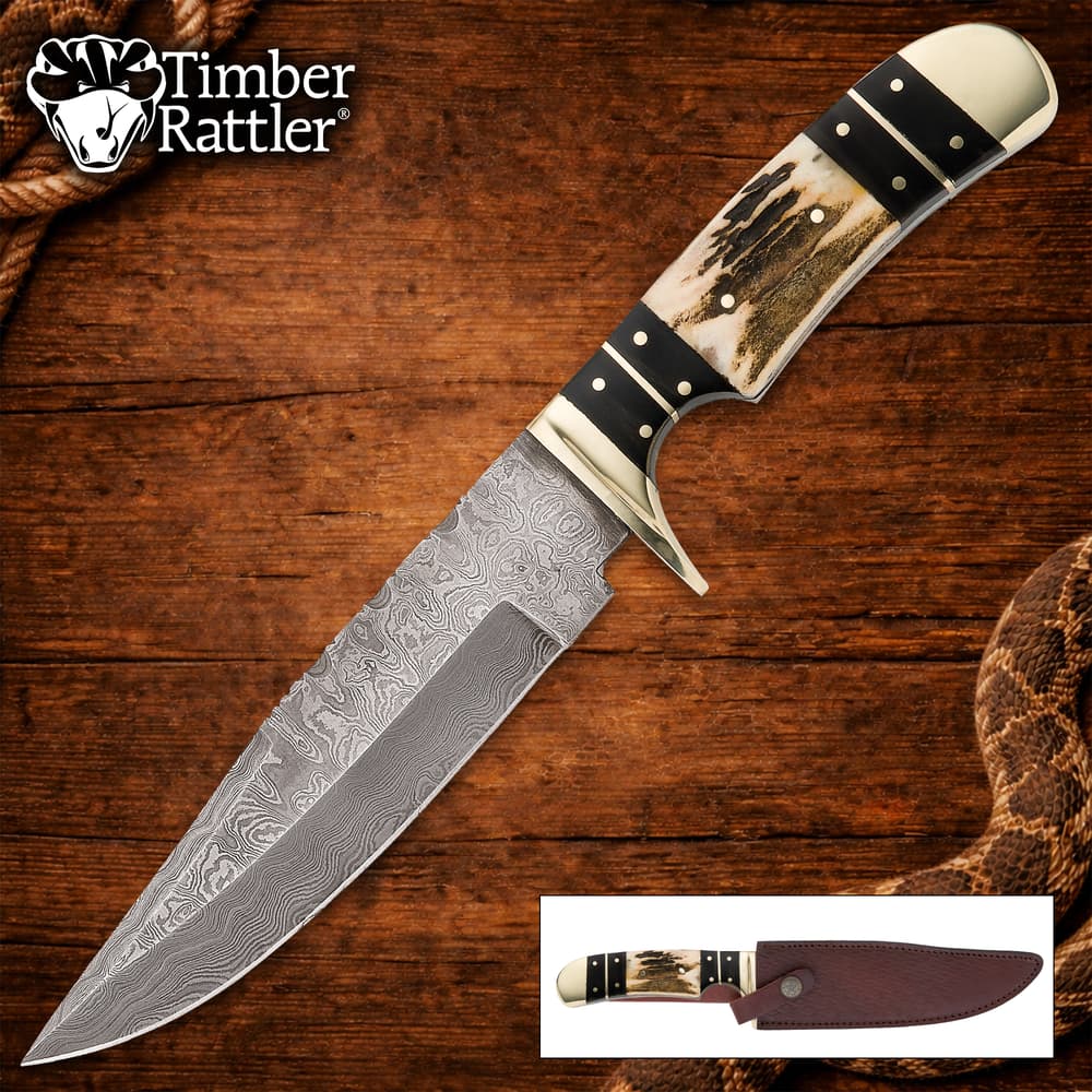 Damascus knife with stag handle on wooden background image number 0
