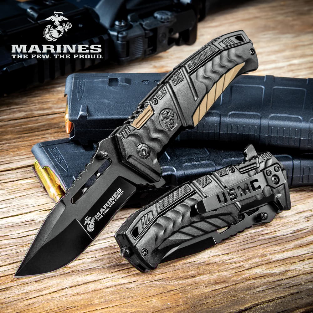 Black tactical knife with USMC logo on wooden surface image number 0