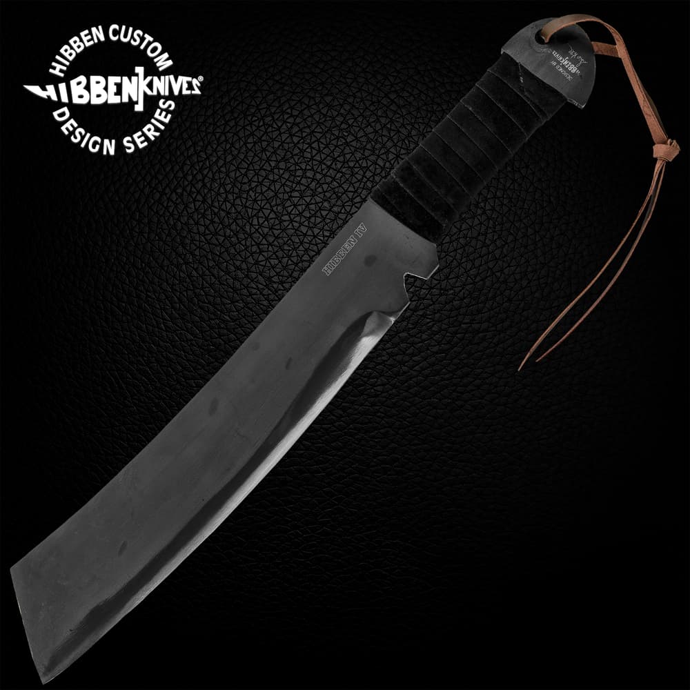 Gil HIbben IV Machete Knife is one solid piece of 1090 carbon steel and has a black cord wrapped handle, shown on wooden background. image number 0