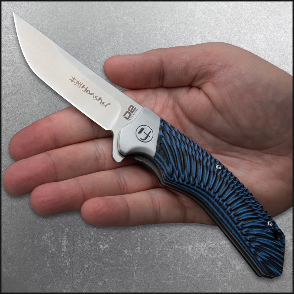 Open pocket knife with an inscription of "Honsu" on the blade and a tie-dye style blue and black handle. image number 3