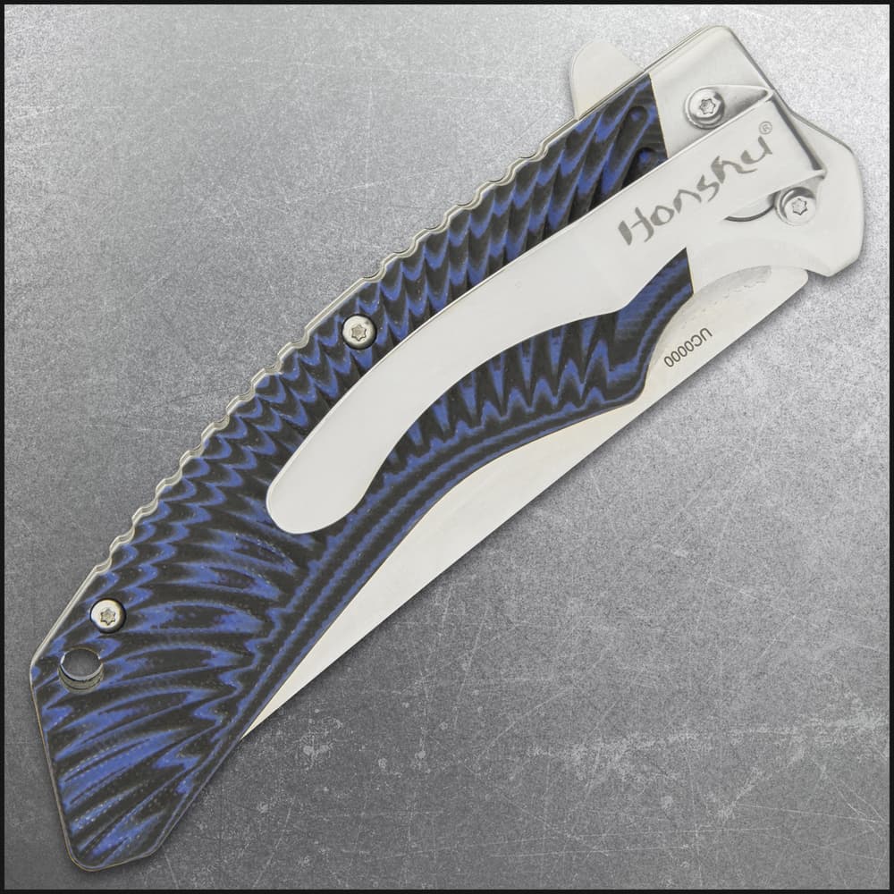 Closed pocket knife with large pocket clip inscribed with "honshu" and a tiedye style blue and black handle. image number 4