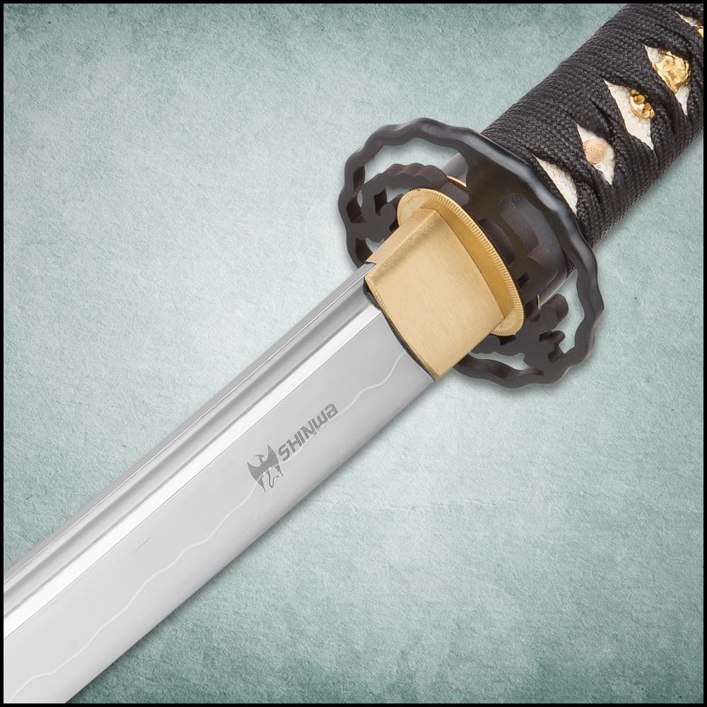 The katana, wakizashi, and tanto of the set laid side-by-side with detailed view of the black tsuba and showing swords on wooden display. image number 1