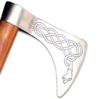 The 4 3/4” wide, 3/16” thick decorated head is crafted of tempered steel and has a 7” long blade