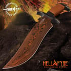 Angled view of the knife with stunning HellFyre Damascus steel blade, laid against a black rock with flame background.