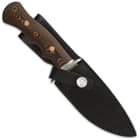 G 10 wood look handle and steel hand guard enclosed in black leather sheath with silver button closure. 
