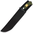 The kukri is housed in a nylon belt sheath, secured with a strap around the handle.